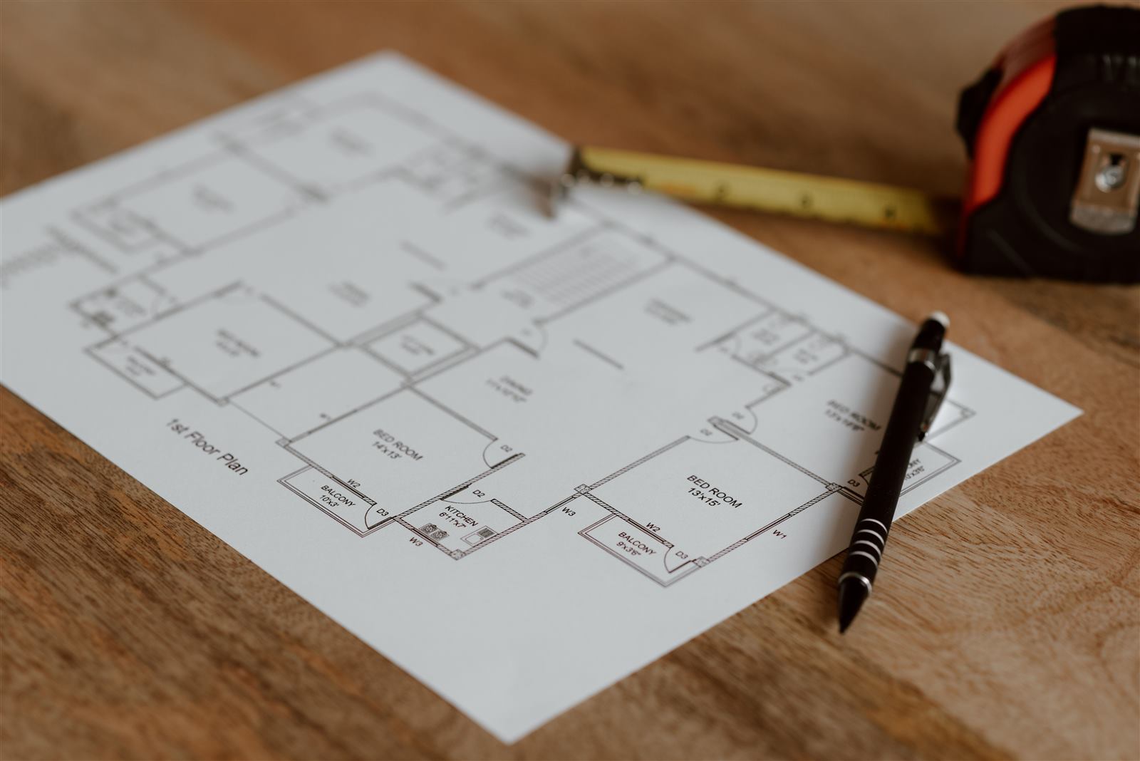 A floor plan with a tape measure and pen