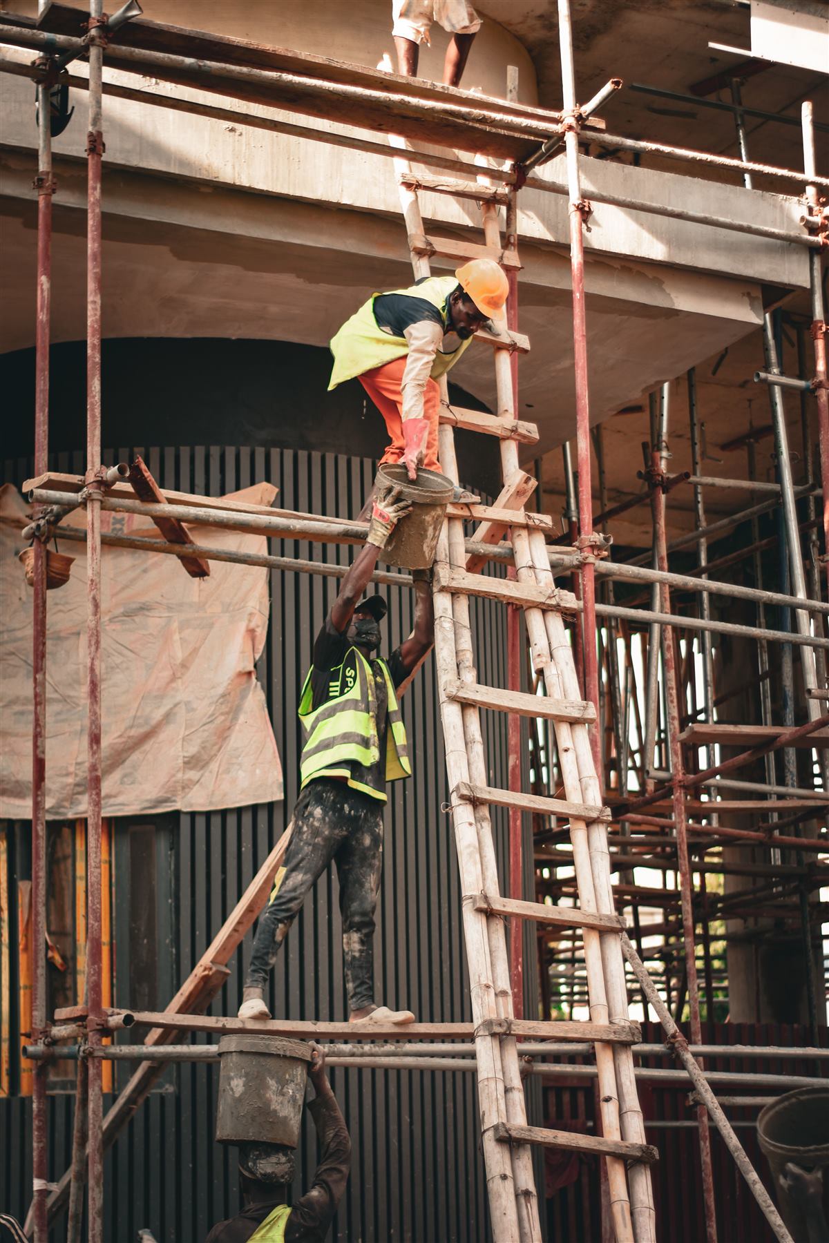 Scaffolding on a building with a worker on a ladder